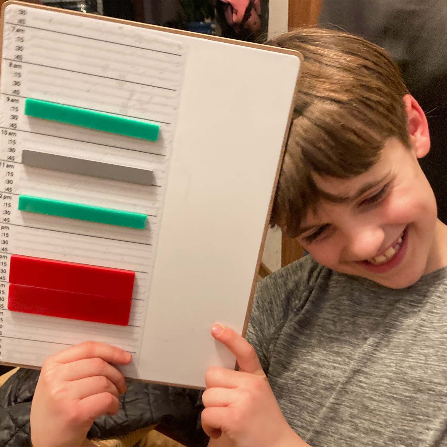 happy child holding a tactiled magnetic board